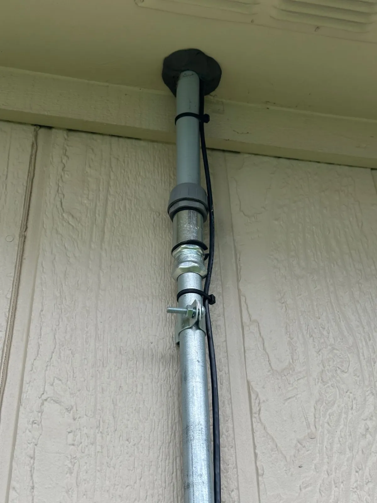 Communications cable zip-tied to the outside of the conduit run instead of being properly routed and protected